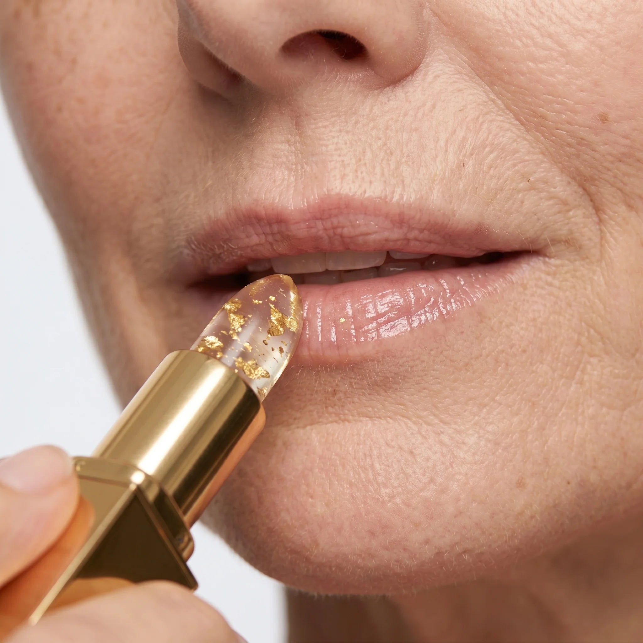 Close-up of applying the clear lipstick to the lips